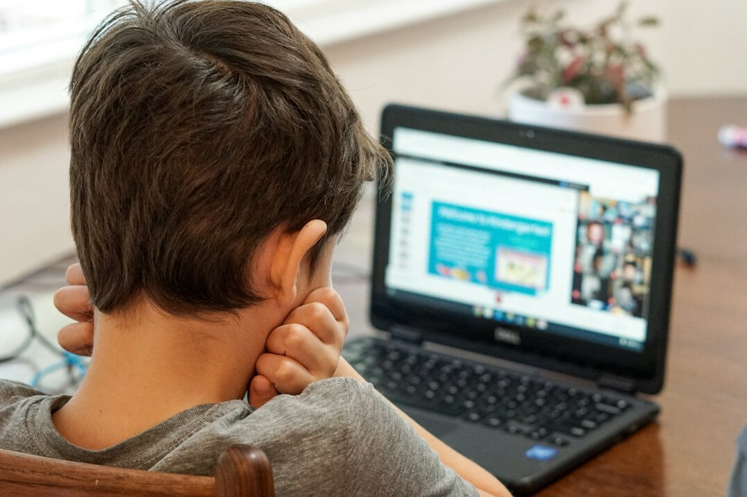 teenager coding on laptop